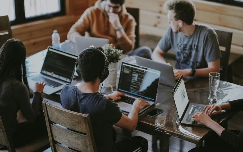 Project team collaborating around a laptop during a working session